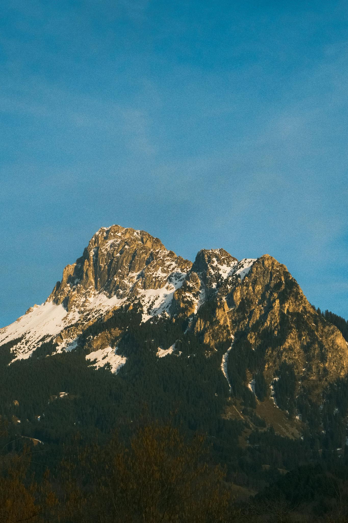 Stunning snow-covered mountain range with clear blue sky, ideal for nature and travel visuals.